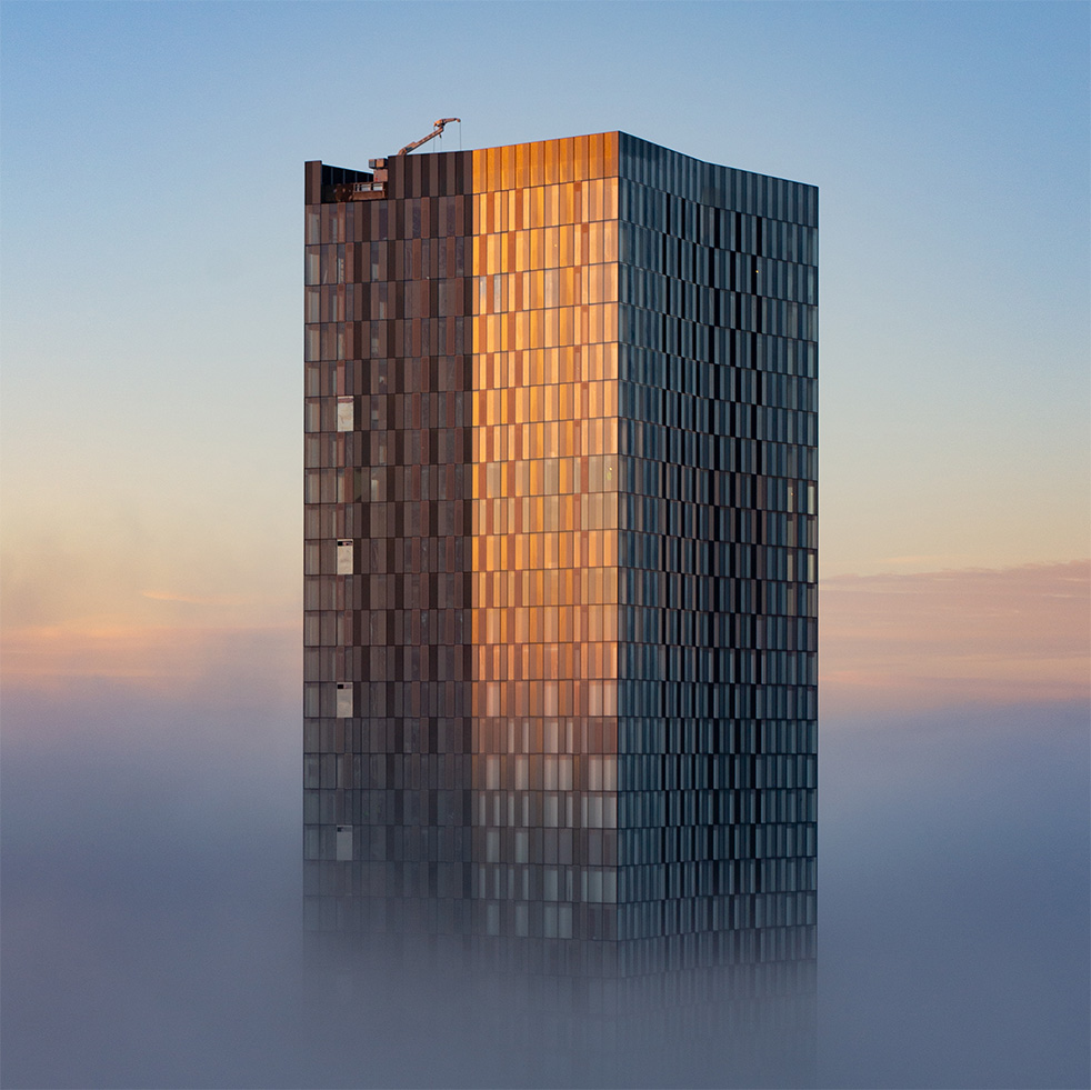 A photo of a cloud inversion where we are above the cloud looking at one of the deansgate towers in Manchester rising above. Sunrise.