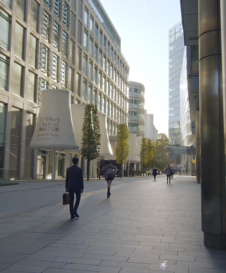 A photo of a business man in the city walking with a briefcase. Spinningfields, Manchester.