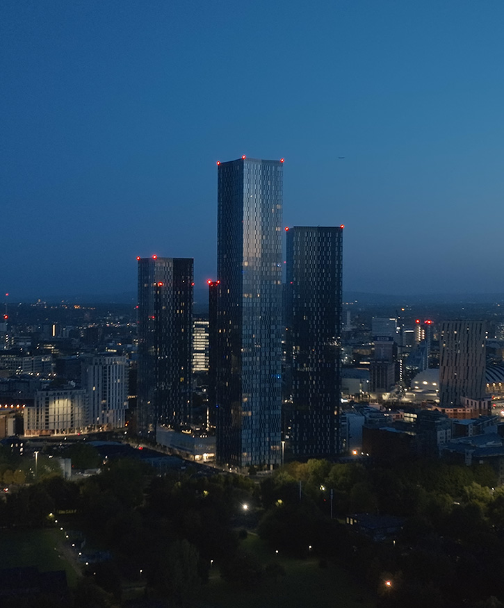 A city centre drone photo of Manchester's deansgate towers during dusk.