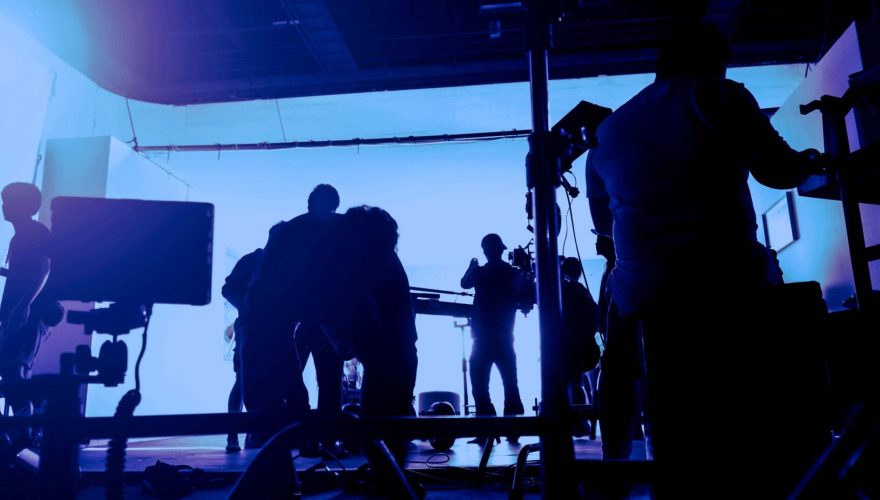 Behind the scenes of shooting video production and lighting set for filming movie which film crew team working in silhouette and professional equipment in studio for video online. video production concept.